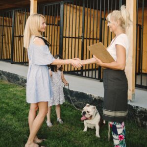 A dog and their owner talking to a doggy daycare owner