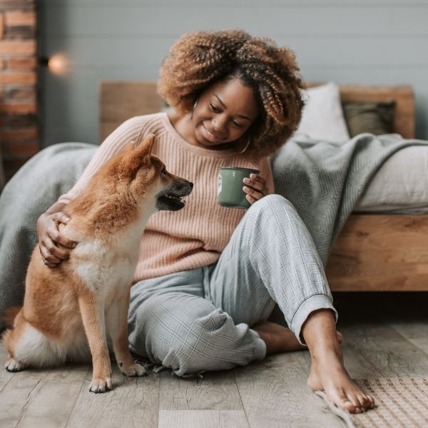 person sitting on the floor with their dog